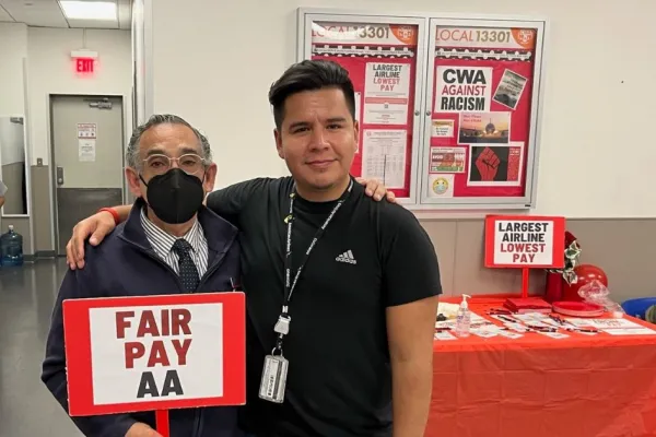 2 American Air members with sign Fair Pay AA