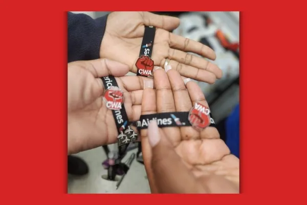 three hands with CWA strong pins on American Airline lanyards