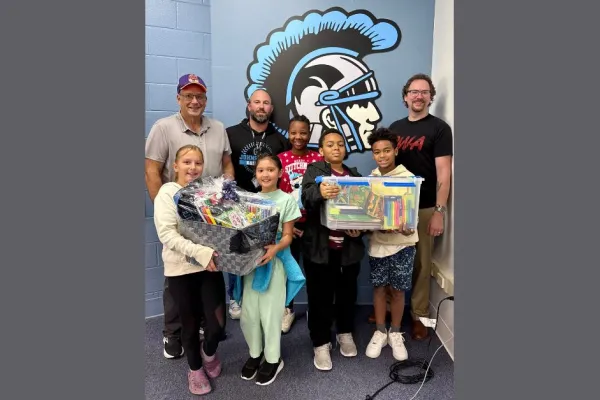 CWA Local 14815 officers with middle schoolers and school supplies