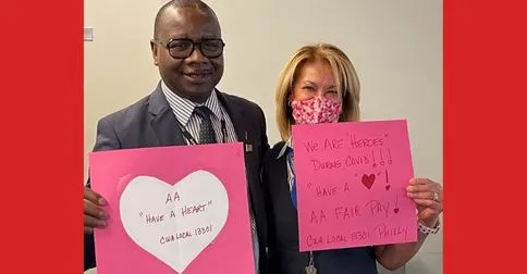 Two American Airlines Passenger Service Agents hold Valentines signs
