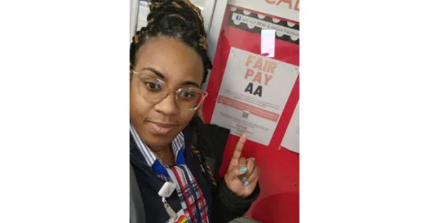 CWA American Airlines member points to Fair Pay AA sign